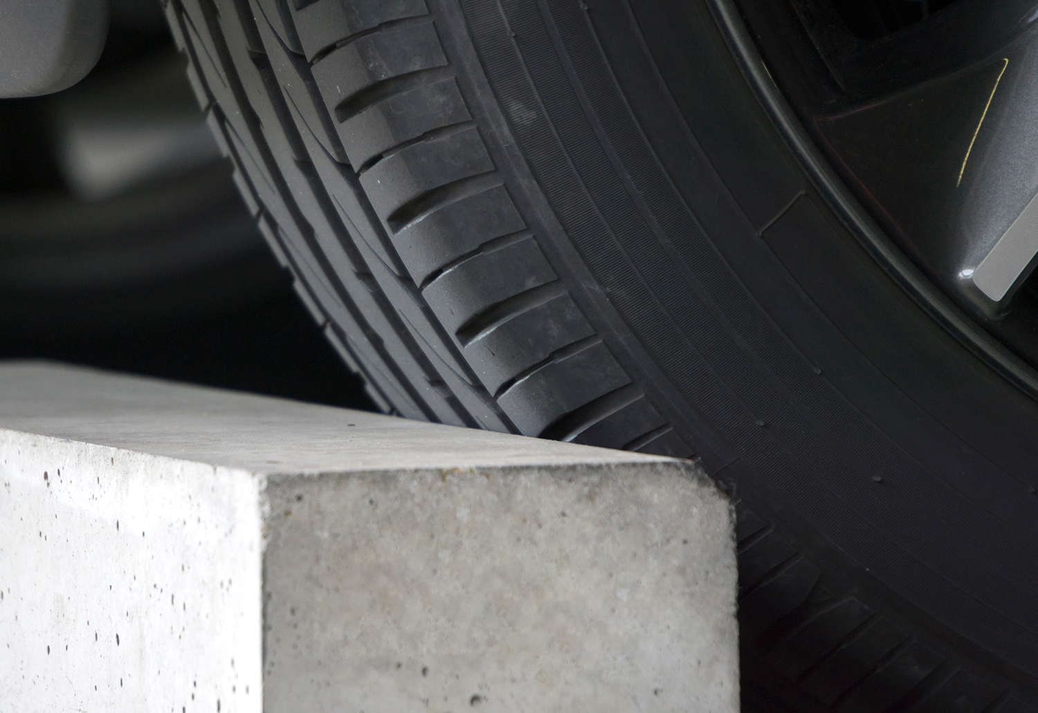 Car's tire touching precast concrete wheel stops